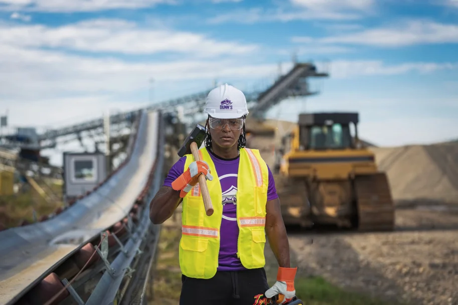 a man in a safety vest and hard hat holding a hammer